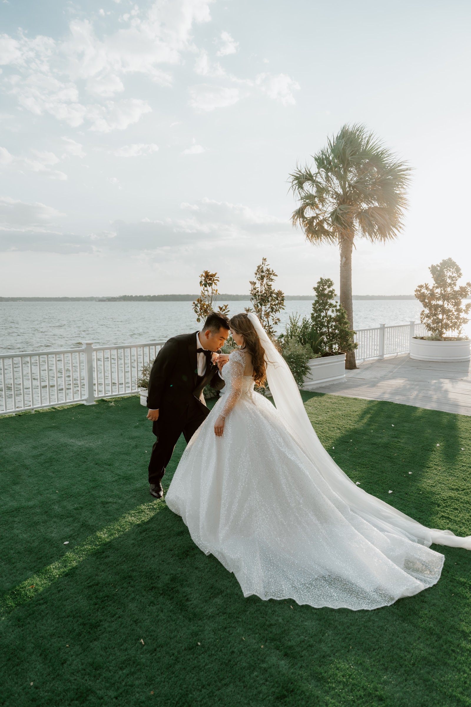 A bride by the shore as the sea wind lifts her wedding dress behind her