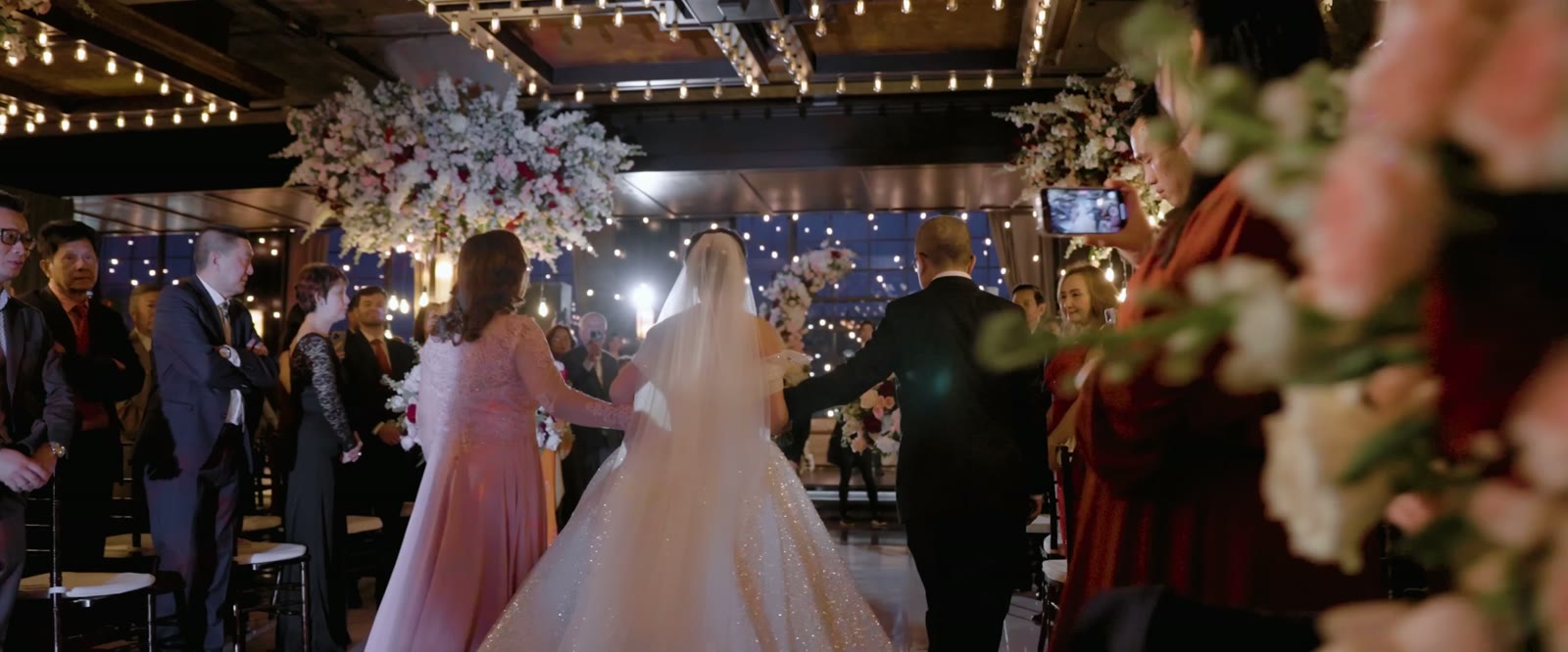 A still frame from Donald and Vy's wedding film: the bride walking down the aisle