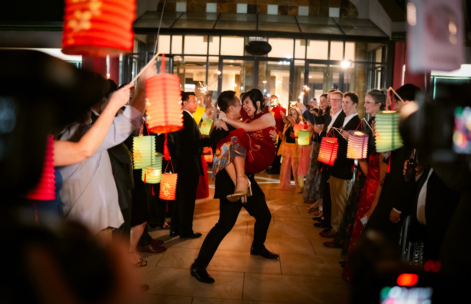 Guests dancing beneath glowing lanterns during the evening celebration
