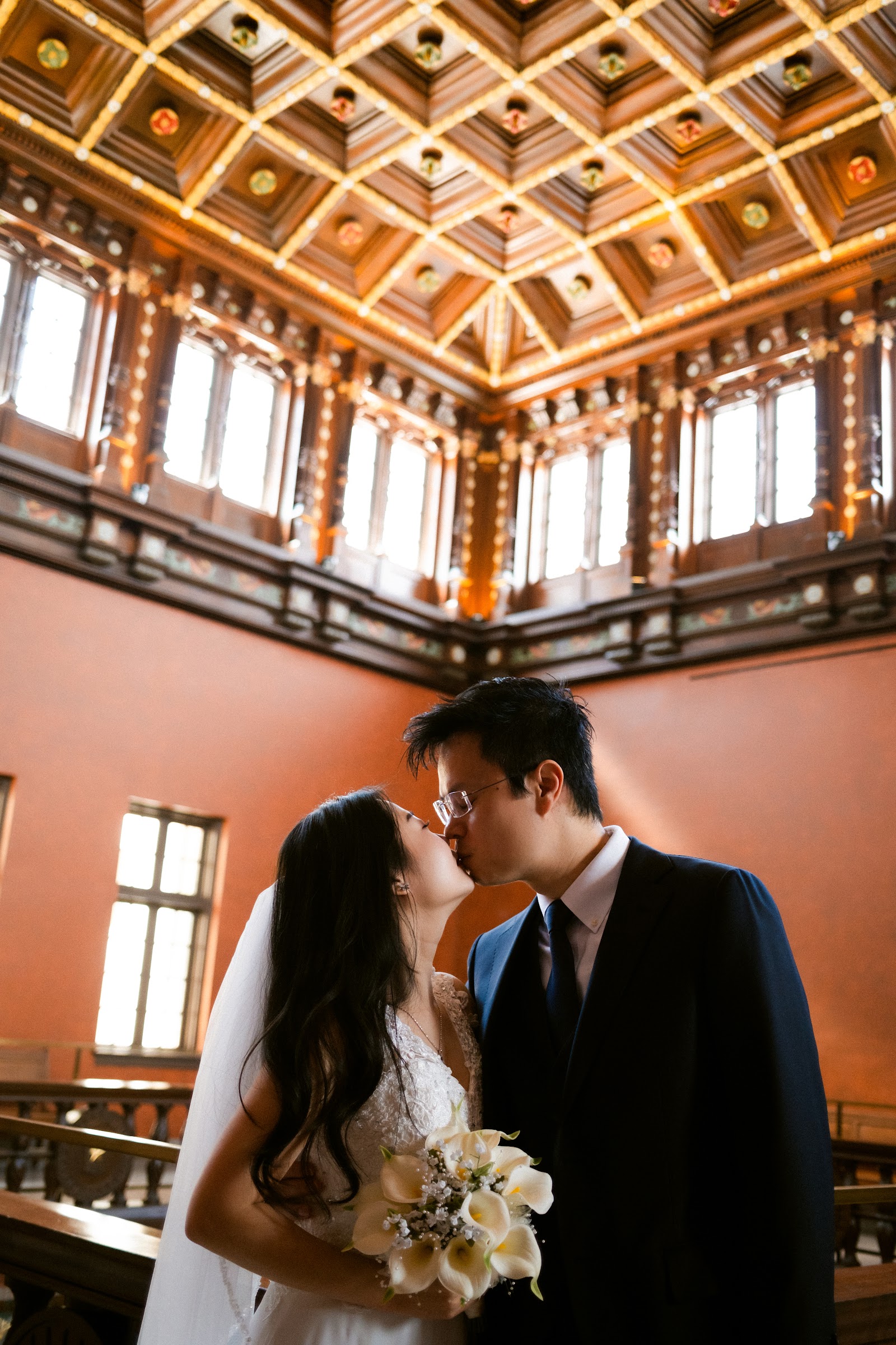 A couple framed by the warm terracotta walls of a historic atrium