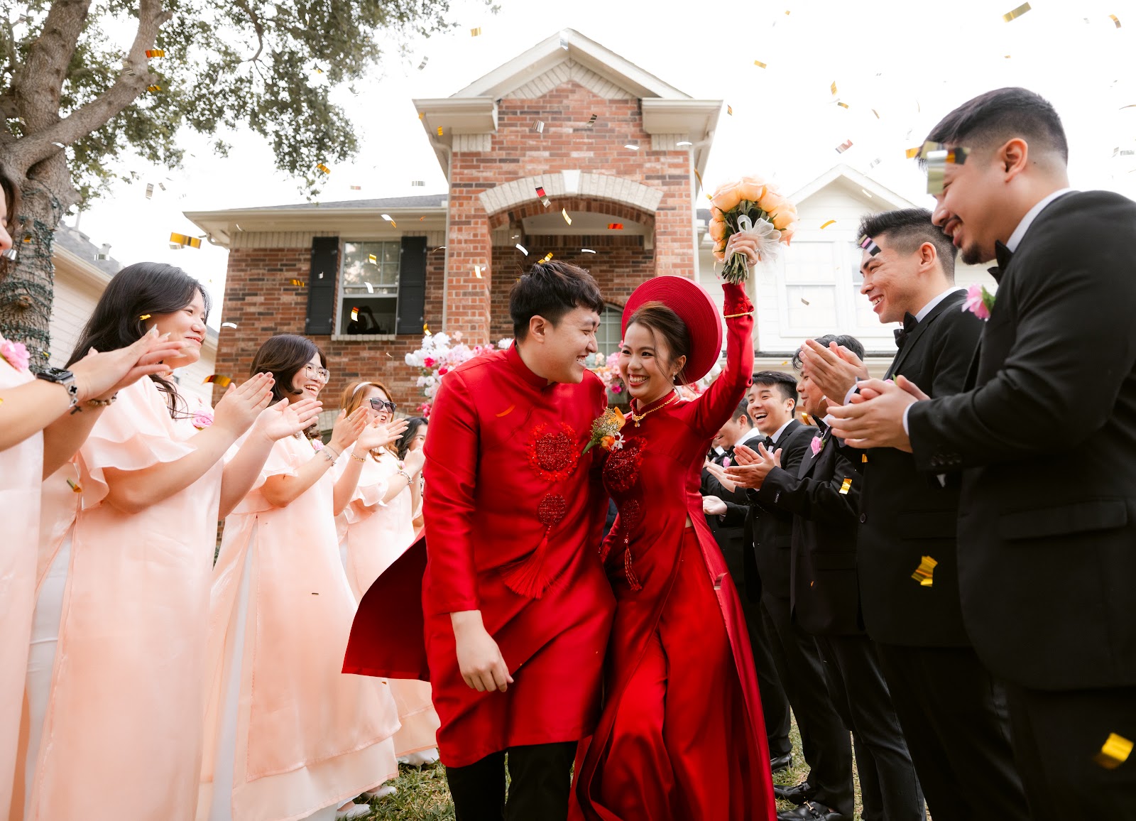 A groom in a red ceremonial robe cheering amid dancers and confetti