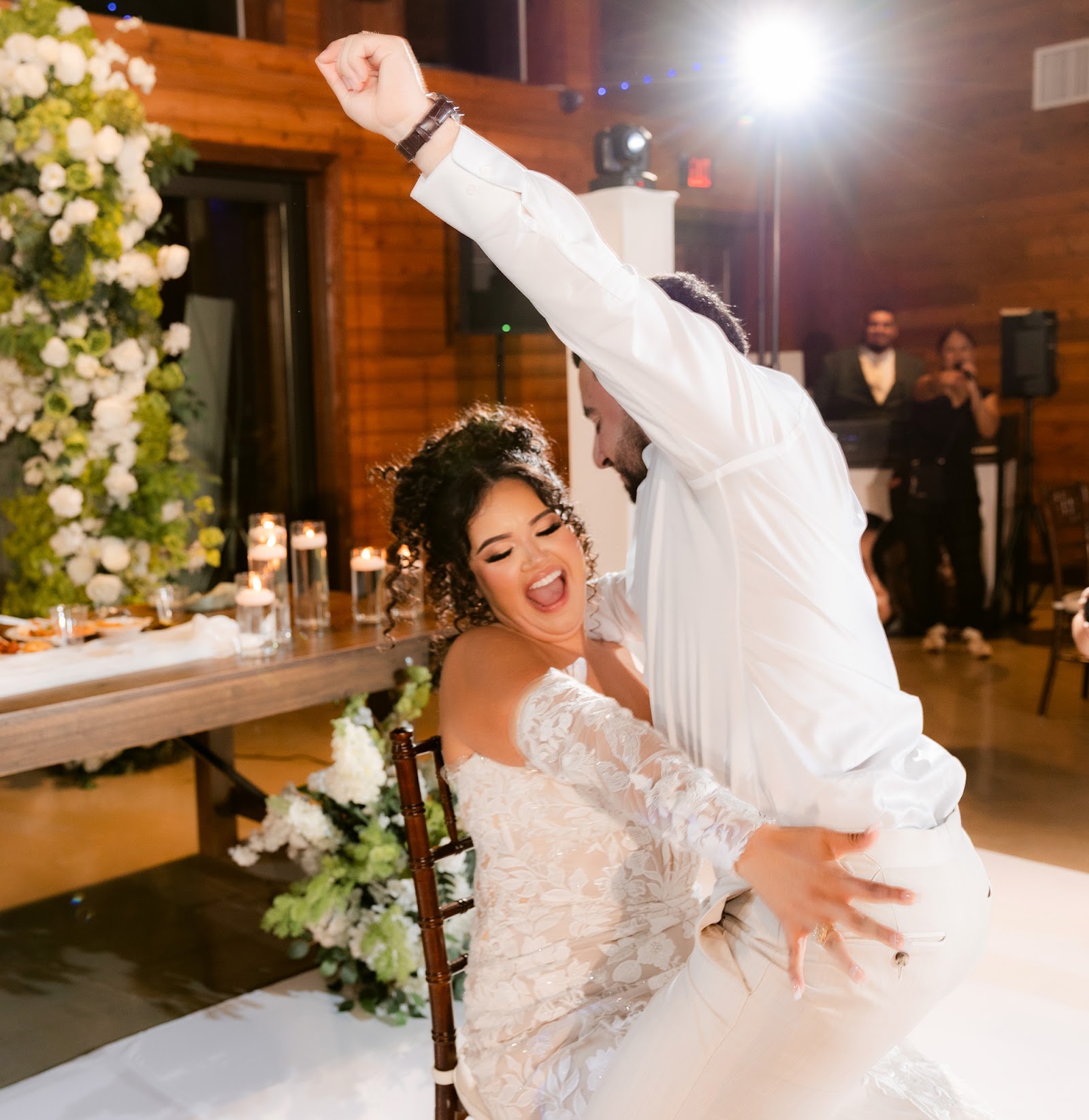A couple dancing closely beneath falling sparklers at the end of their wedding night